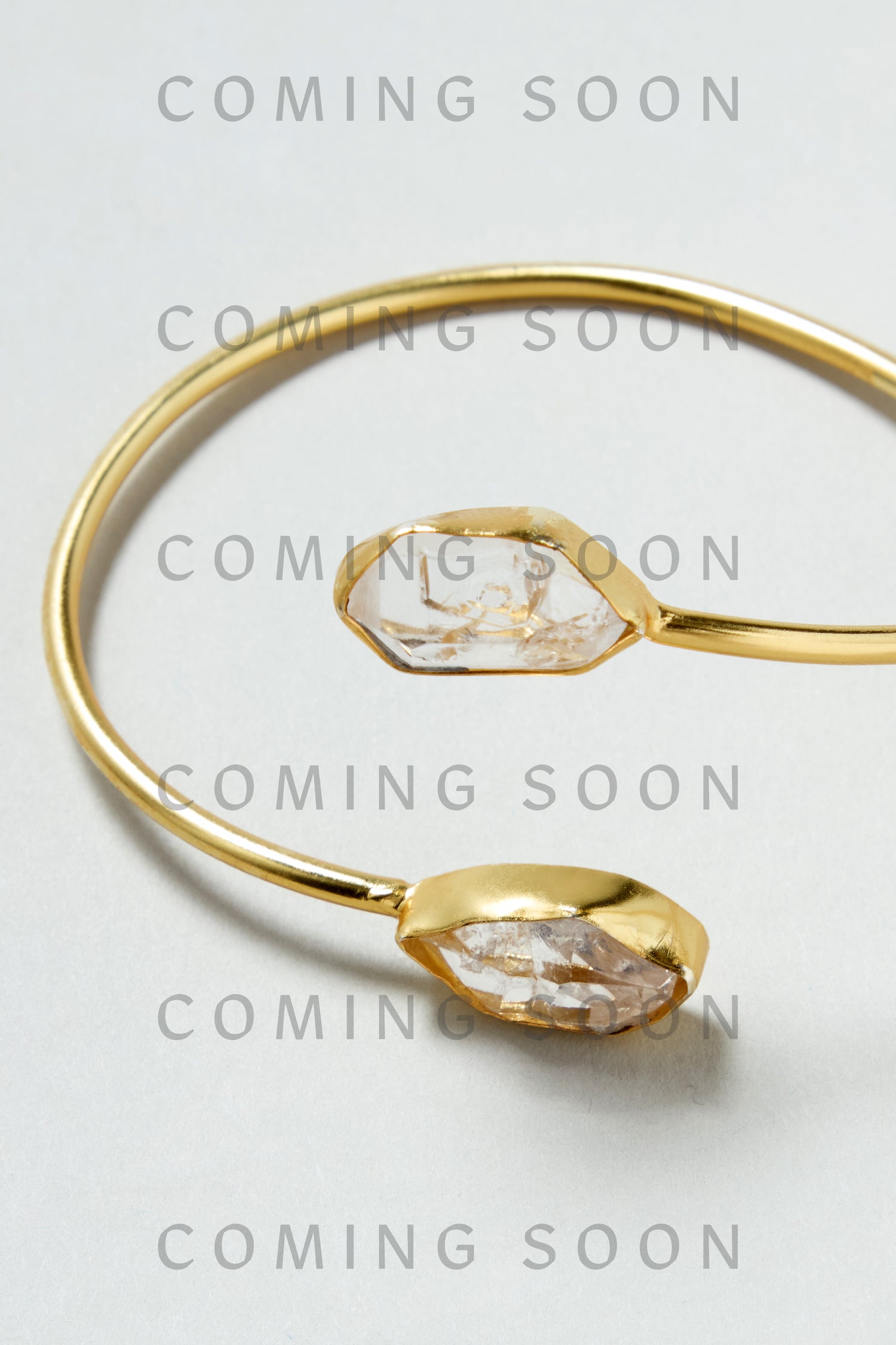Gold Plated Quartz Herkimer Diamond Bracelet with two clear crystals on each end displayed on a light background; overlaid text reads "COMING SOON.