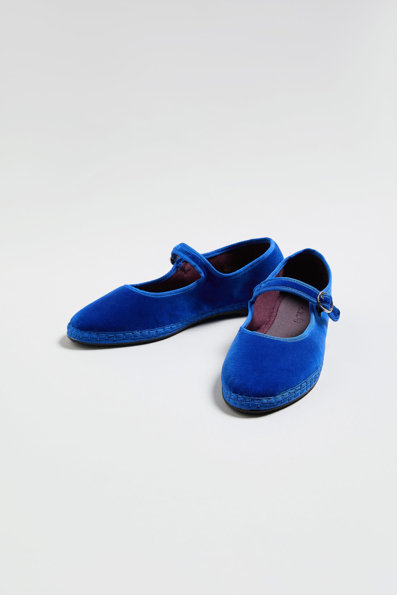 A pair of Mary Jane Velvet Shoes in blue with a thin strap, displayed on a plain light background—an elegant, sustainable fashion choice.