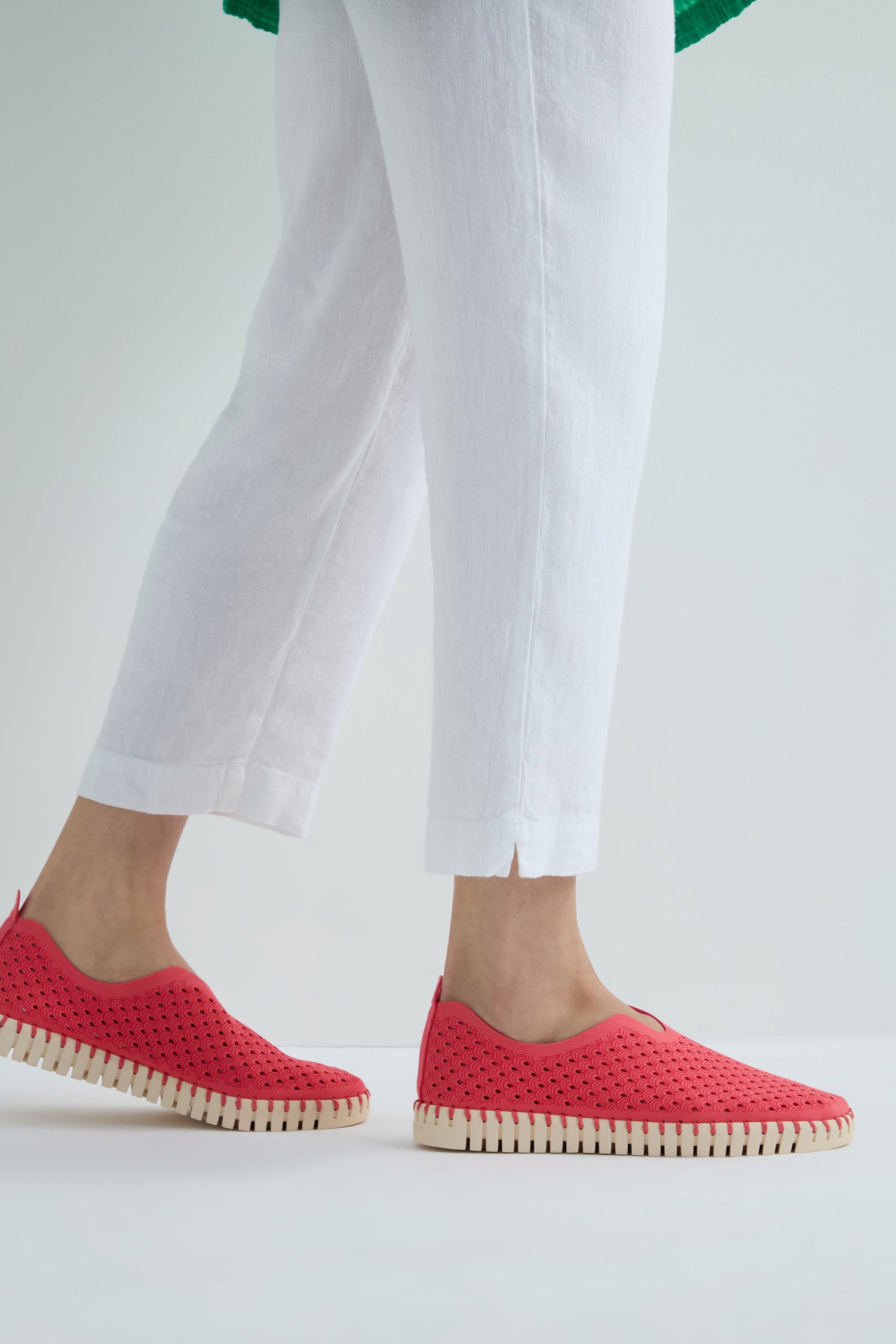 Person wearing white pants and Raspberry Tulip Platform Slip On Shoes, made from recycled microfiber, stands against a plain light background.