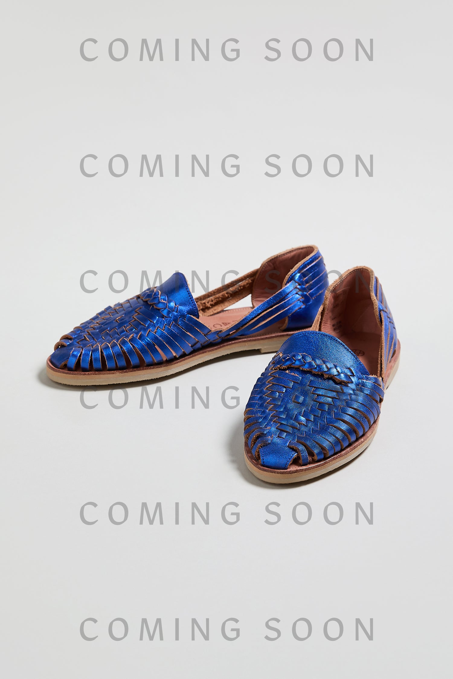 A pair of Metallic Blue Alegre Leather Huarache Sandals on a white background with "COMING SOON" repeatedly overlaid—an online exclusive.