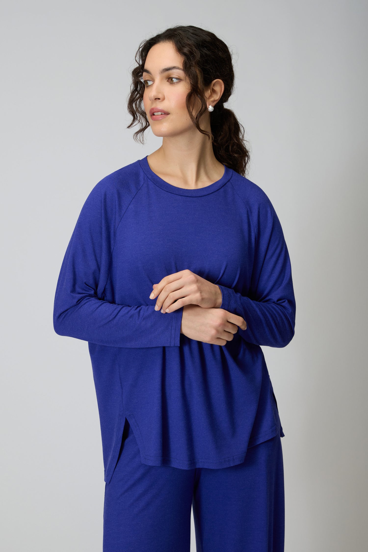 A person in the Soft Viscose Jersey Boxy Top and matching blue relaxed-fit pants stands against a plain light background, gazing slightly to the side.