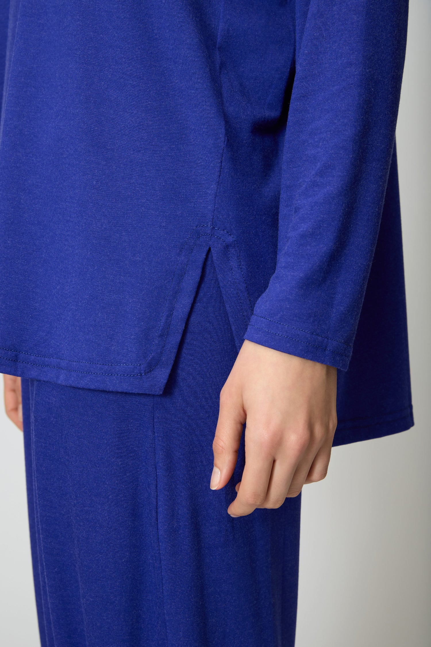 A person wears the Soft Viscose Jersey Boxy Top in blue with matching pants, both in a relaxed fit. Shown from torso down, one arm rests casually at their side.