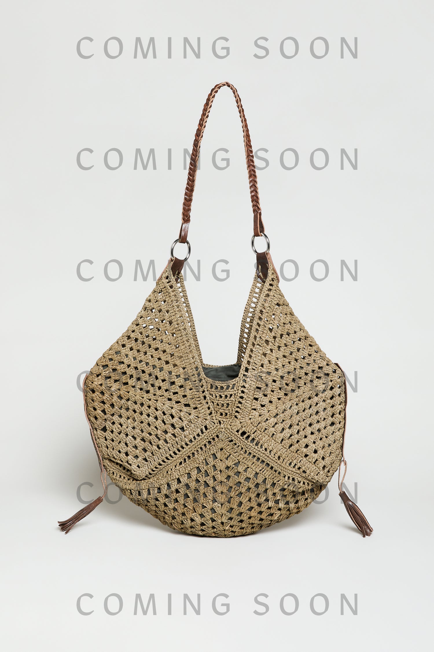The Handwoven Raffia Tassel Detail Handbag features brown leather handles and tassel accents. Displayed against a plain background, the image includes a "COMING SOON" overlay. Style TON12315.