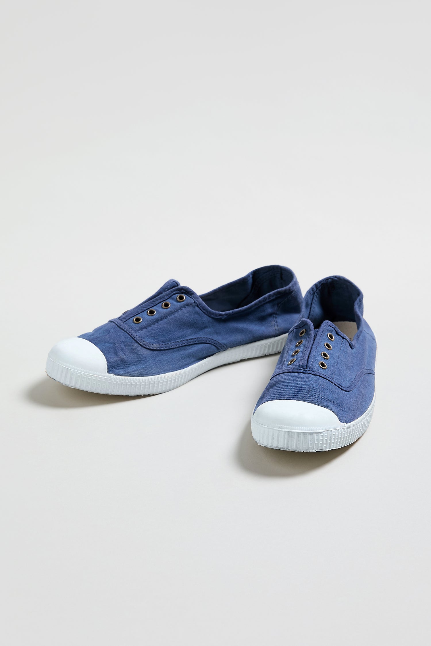 A pair of Inglesa Navy Pumps canvas slip-on sneakers with white rubber toe caps and soles, displayed on a plain light background.