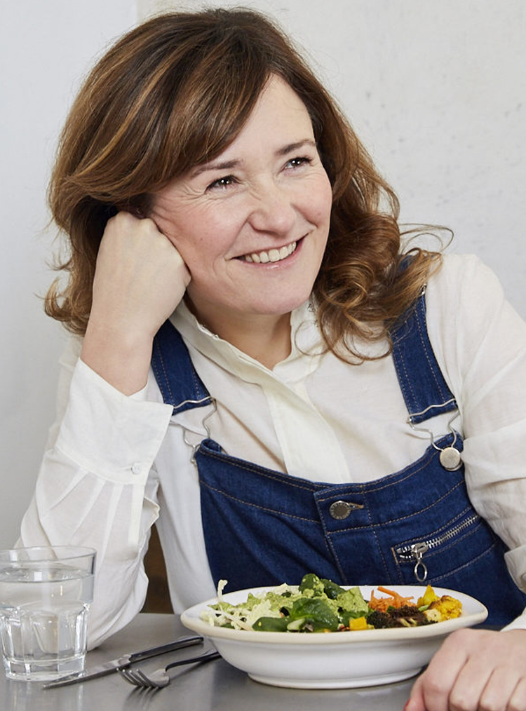 woman sat at a table eating a salad