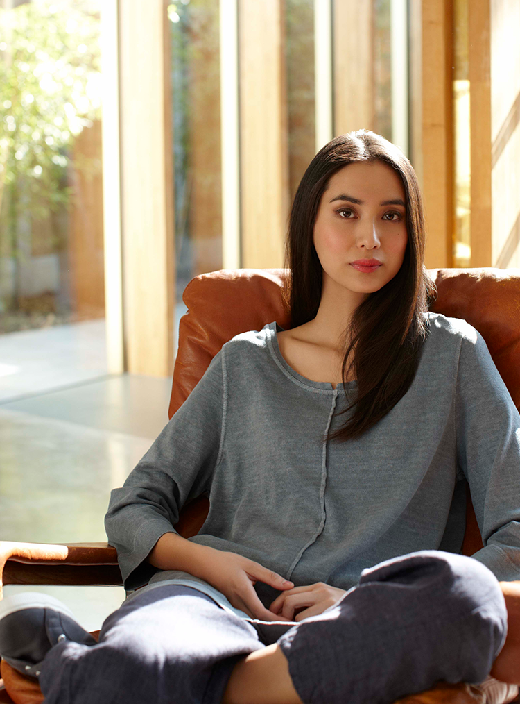 woman in a grey tunic sat on a chair