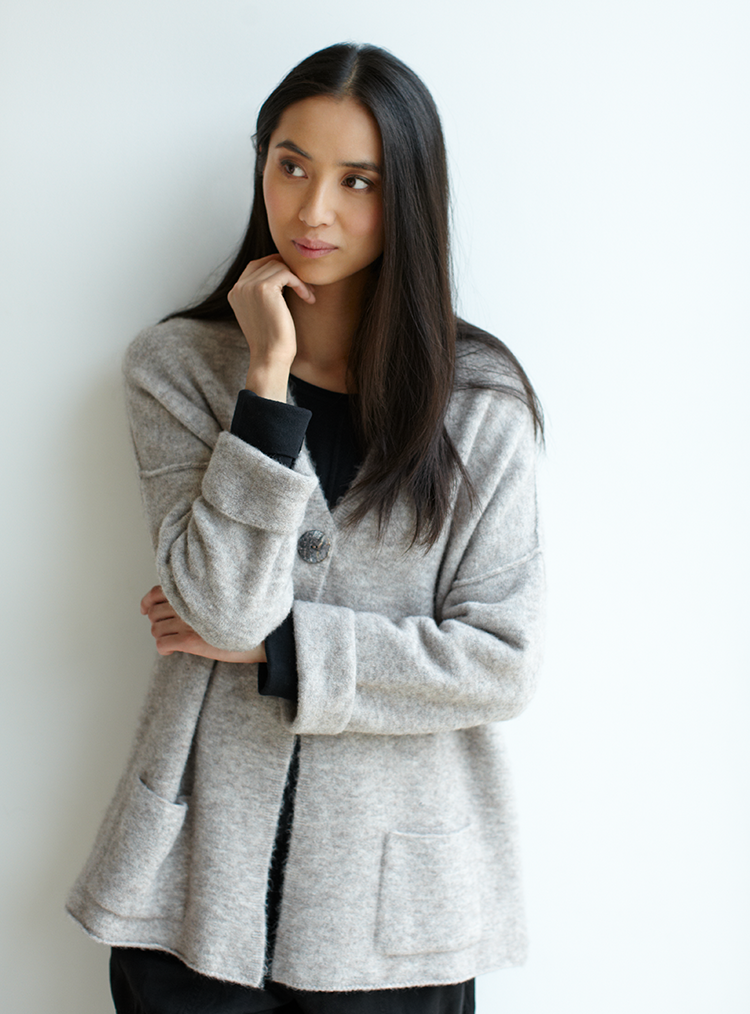 woman stood in a grey knitted jacket