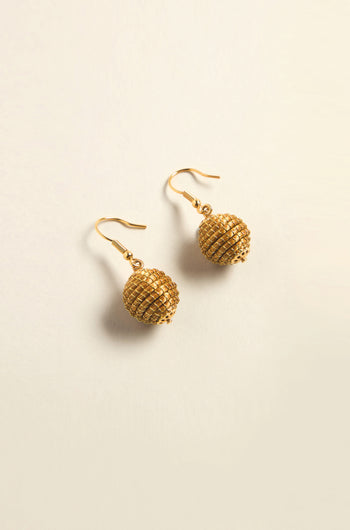 The Golden Grass Woven Sphere Earrings exemplify handcrafted artisan jewelry with textured gold spheres and elegant hook fastenings.