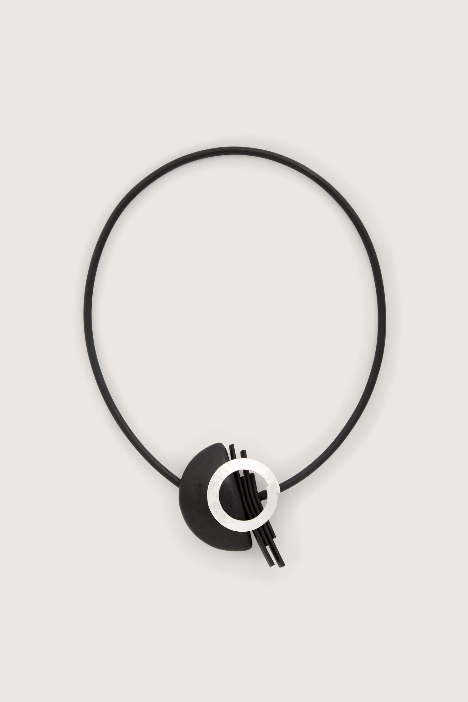 A black and white Saturn Necklace with a circle on it, perfect for jewellery making.