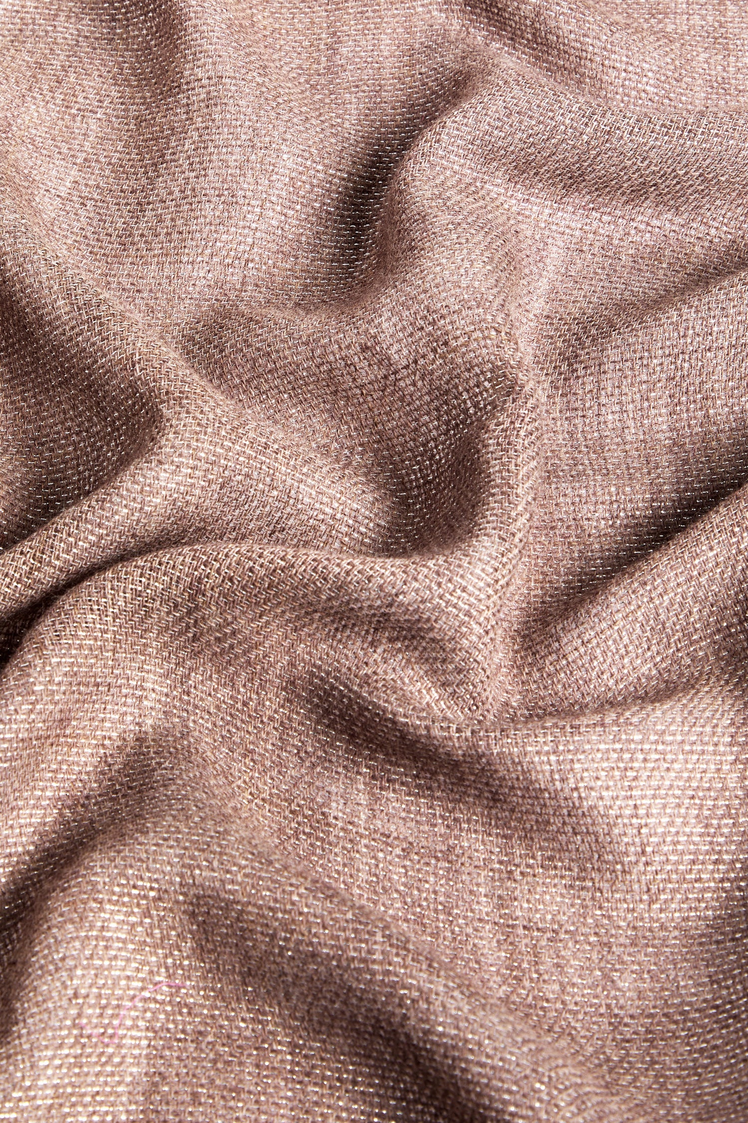 Close-up of the Sparkle Scarf in beige fabric with a textured weave, elegantly draped with gentle folds and slight shadows, subtly enhanced by contrasting metallic threads.