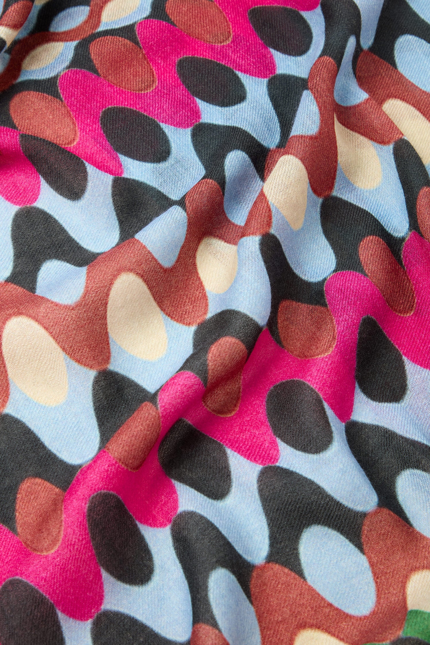 Close-up of the Retro Waves Wool Mix Scarf showcasing a wavy, abstract pattern in black, red, pink, brown, and light blue. The material appears soft and textured, evoking a vintage aesthetic.