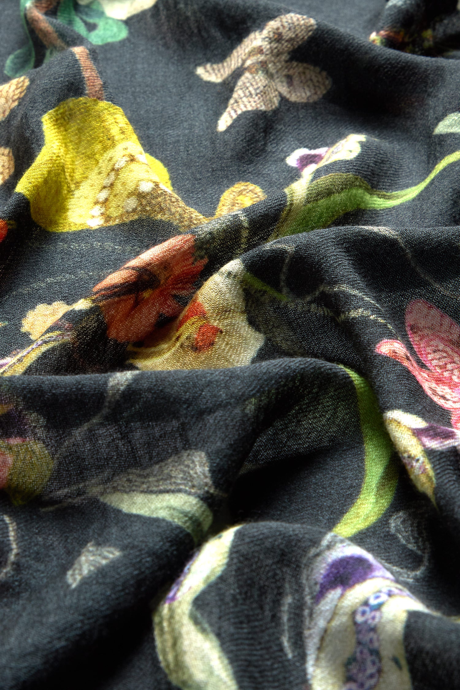 Close-up of a Vintage Floral Wool Scarf, displaying luxurious wool fabric with a vibrant floral pattern in various colors, highlighting its delicate folds and rich texture.