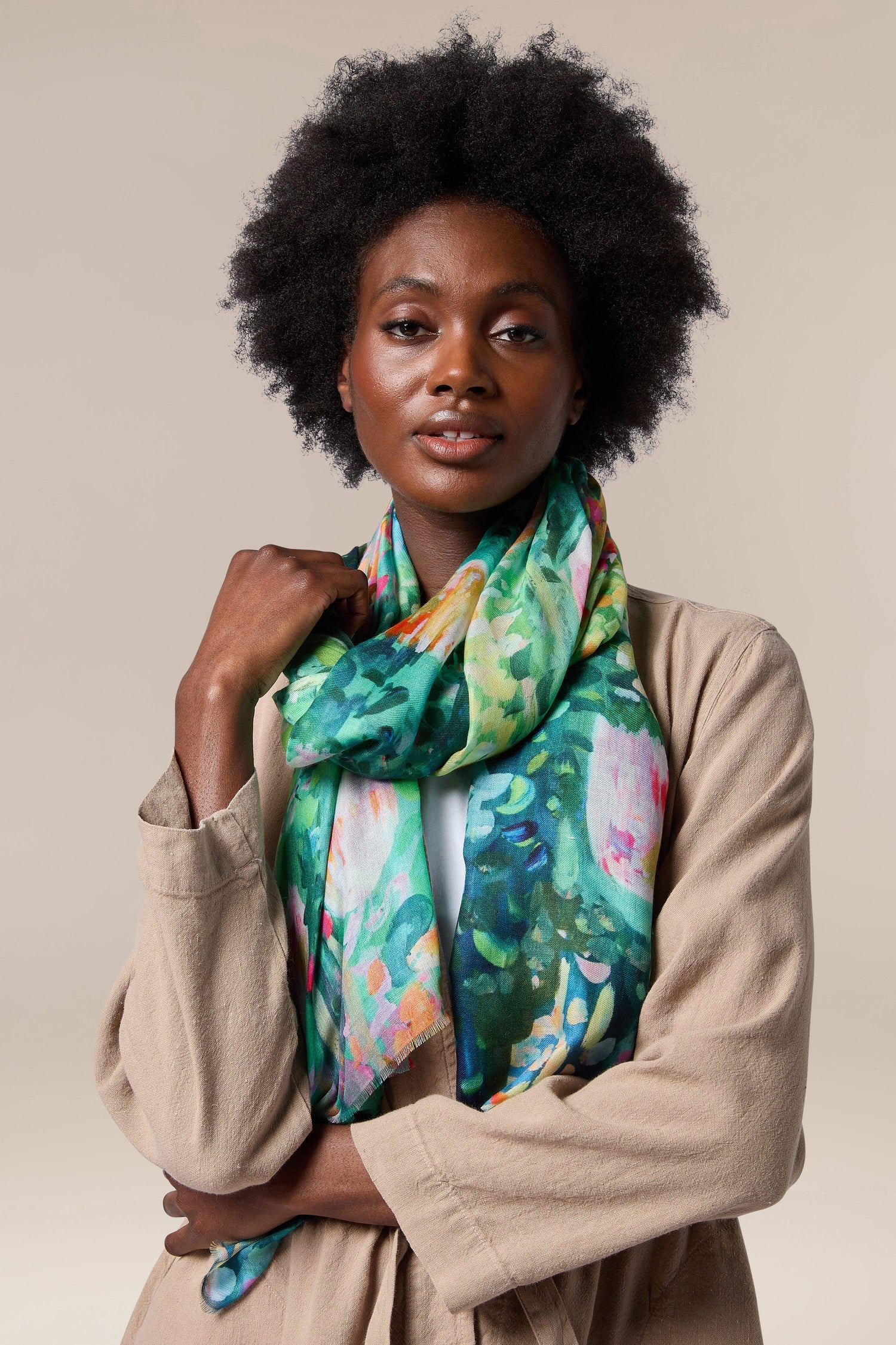 A black woman wearing a Monet's Garden Modal Silk Scarf in green.