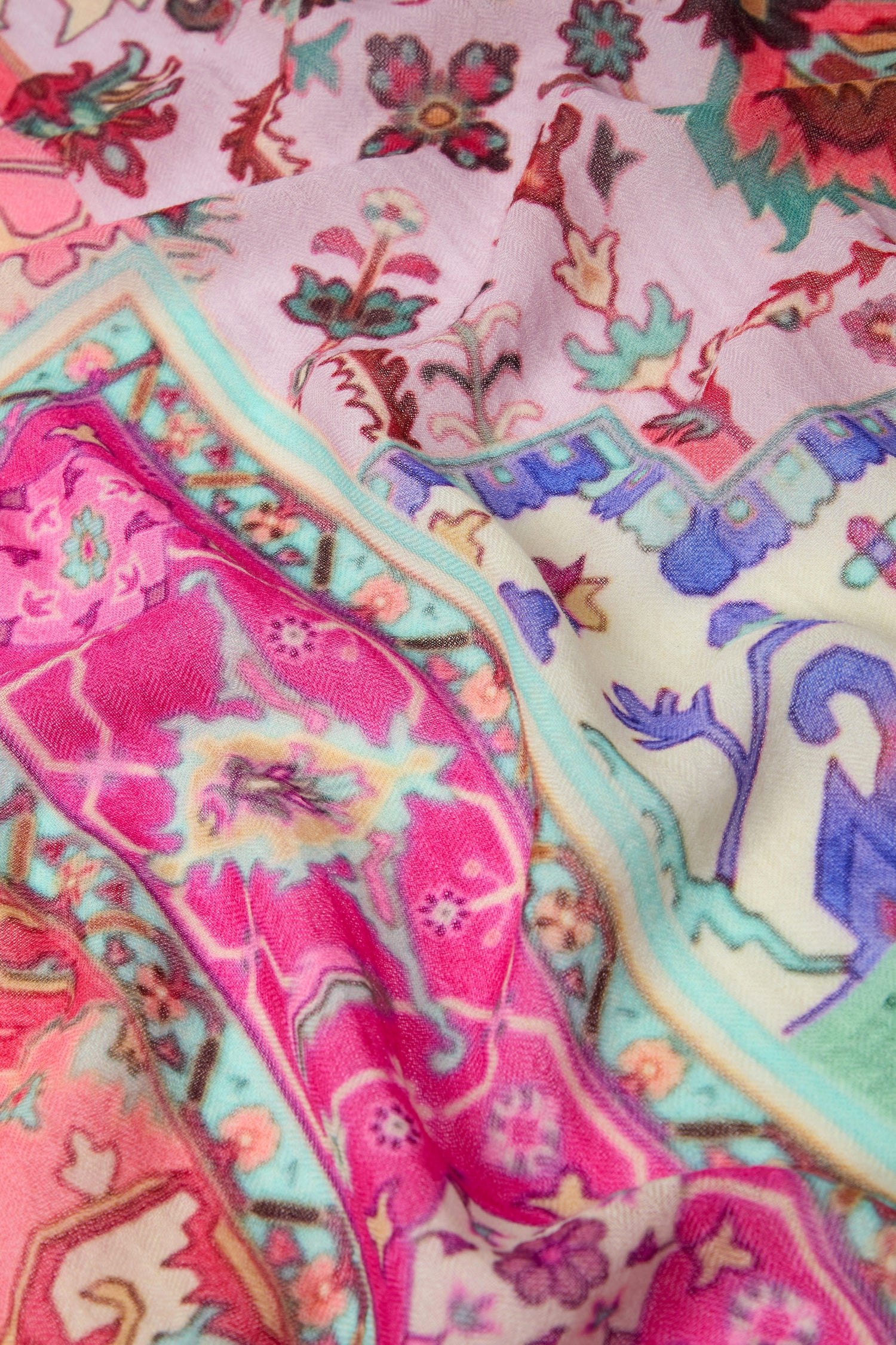 A close-up view of the Medina Wool Scarf showcases a vibrant array of floral and geometric designs in pink, blue, purple, and green hues, making it perfect for all-occasion styling with medina-inspired motifs.