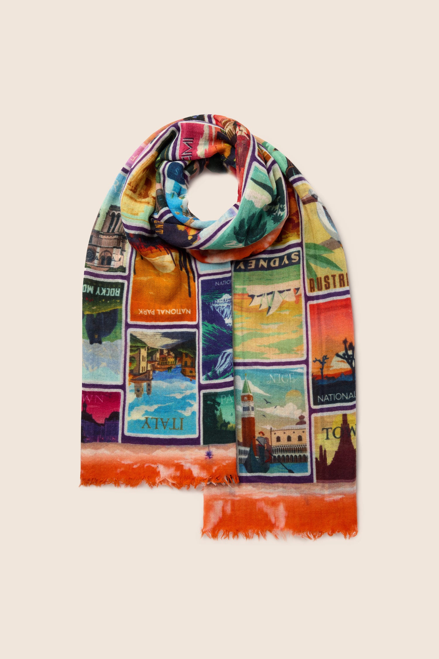 The "Postcards From Around the World" Wool Scarf is a colorful accessory adorned with a collage of travel posters from various destinations. It features frayed edges and a predominantly orange border, making it perfect for versatile styling on any occasion.