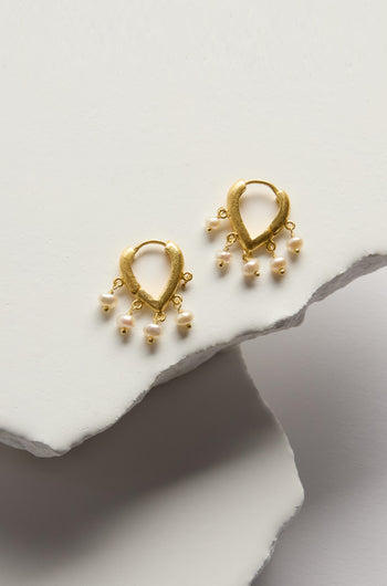 Gold Vermeil Pearl Teardrop Hoops: 18k gold vermeil clicker hoop earrings with teardrop shapes and small dangling white pearls, shown on overlapping white textured surfaces.