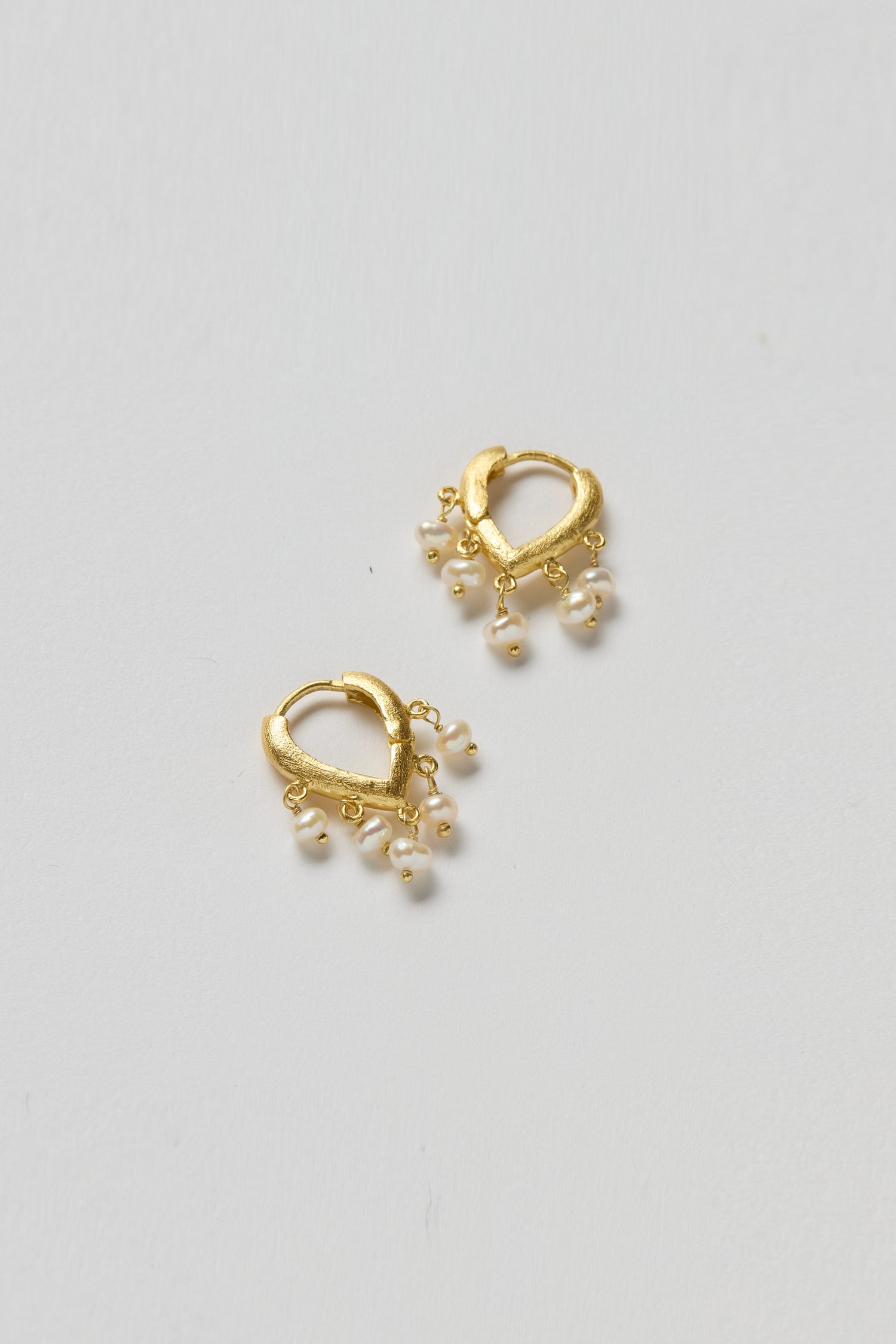 Gold Vermeil Pearl Teardrop Hoops: Small 18k gold vermeil clicker hoops with dangling white pearl teardrop charms, shown against a plain light background.