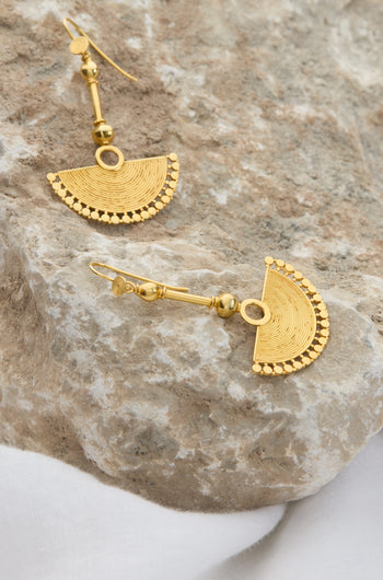 The 18ct Gold Vermeil Fan Earrings with intricate patterns rest on a textured stone surface, exuding bohemian elegance.