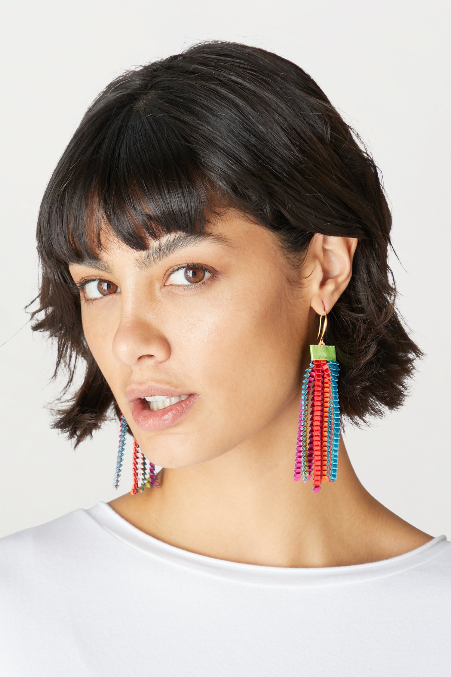 A woman wearing Pleated Earrings made of synthetic-silk.