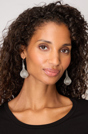 Woman with curly hair wearing a black top and large, lightweight Hand Crocheted Teardrop Earrings, looking at the camera with a neutral expression.
