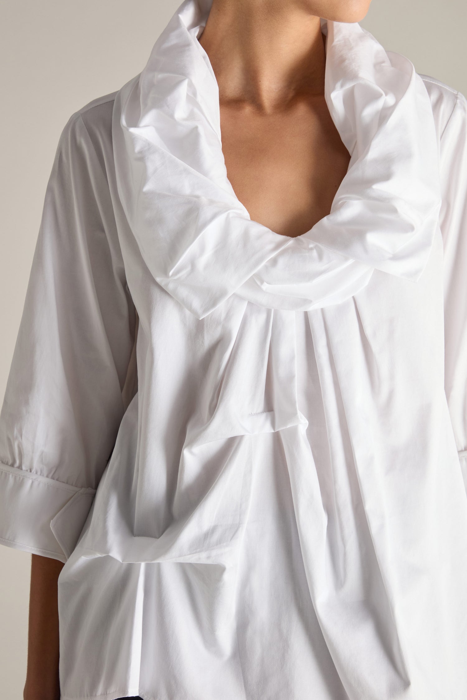 Person wearing a Frill Neck Easy Top, which features avant-garde tucking details on a white blouse, a large ruffled collar, and three-quarter sleeves with cuffs.