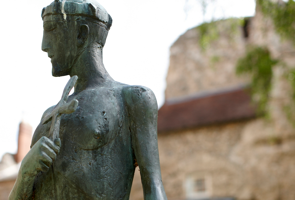 statue of a man holding a cross