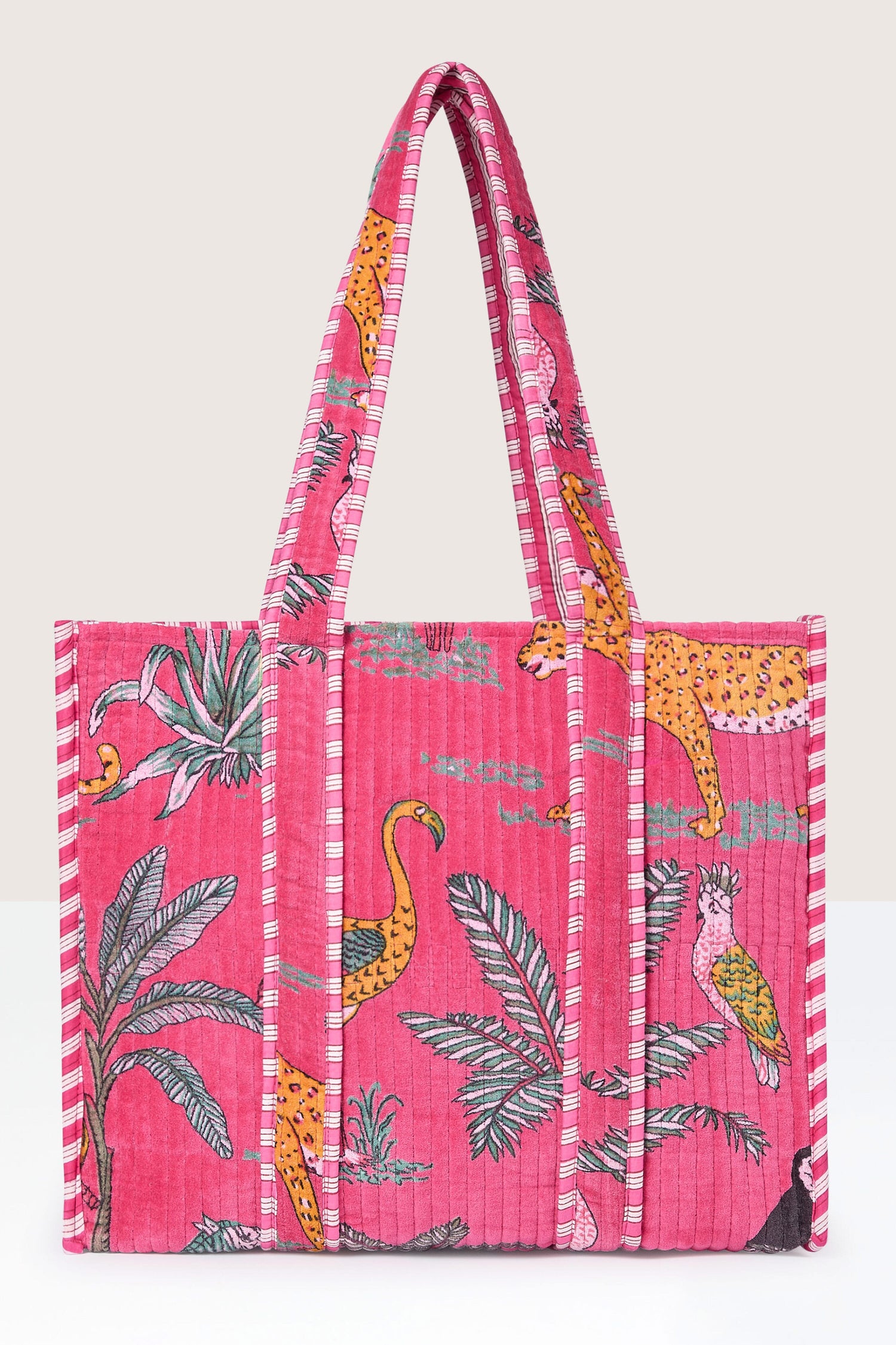 A Jungle Print Velvet Bag featuring colorful patterns of cheetahs, tropical birds, and palm leaves, with striped handles.