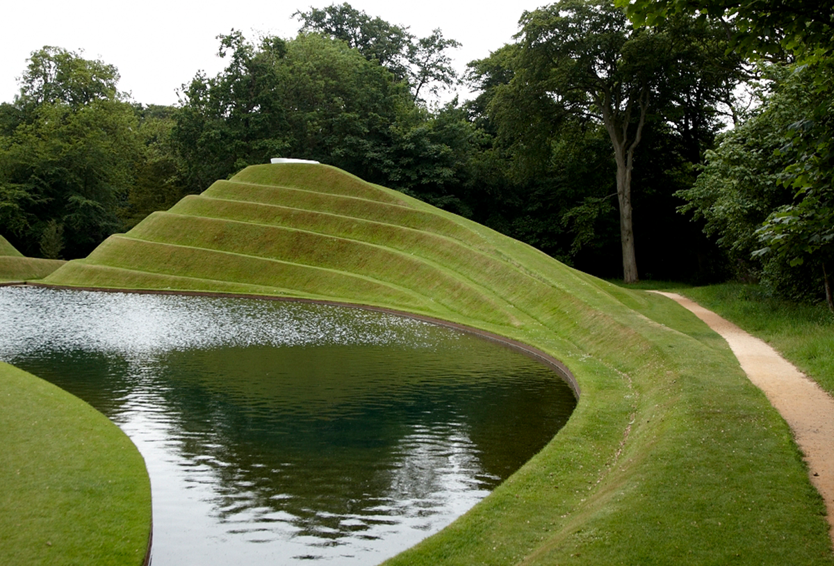 layered grass hill next to water