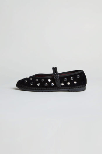 The Studded Mary Jane Velvet Shoes feature black velvet, a buckle strap, and multiple silver eyelets along the sides, exemplifying elegant handmade Spanish footwear against a plain white background.