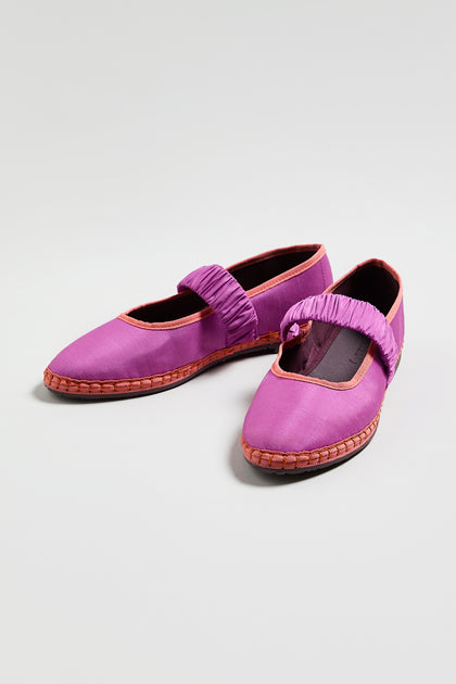 Mafalda Silk Shoes—purple slip-ons with elastic straps, orange trim, and brown woven soles—are an online exclusive from FLBMAFALDAS, shown on a plain light background.