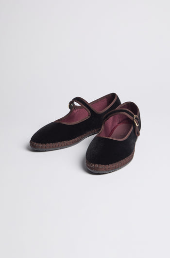 Black Mary Jane Velvet Shoes with maroon inner lining and buckled straps, crafted using traditional Spanish shoemaking techniques, displayed on a plain white background.