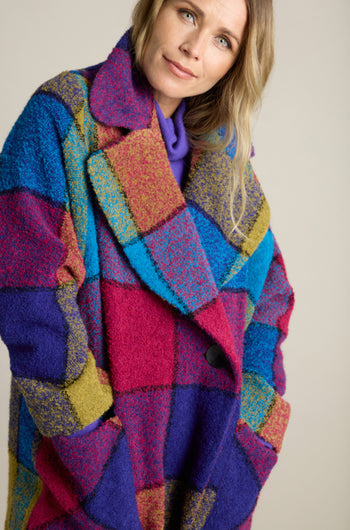 A person wearing a Check Wool Coat, crafted from vibrant woven boucle wool, stands against a plain background.