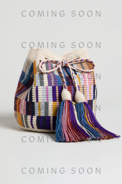 The Hand Crocheted Wayuu Crossbody Bag features a colorful woven design, drawstring closure, and two large tassels. Displayed on a plain background with "COMING SOON" text—item code GNG12W00013332.