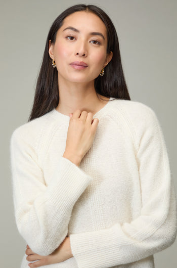 A woman with long dark hair wears the Alpaca Blend Seam Detail Jumper and gold earrings, posing against a neutral background.