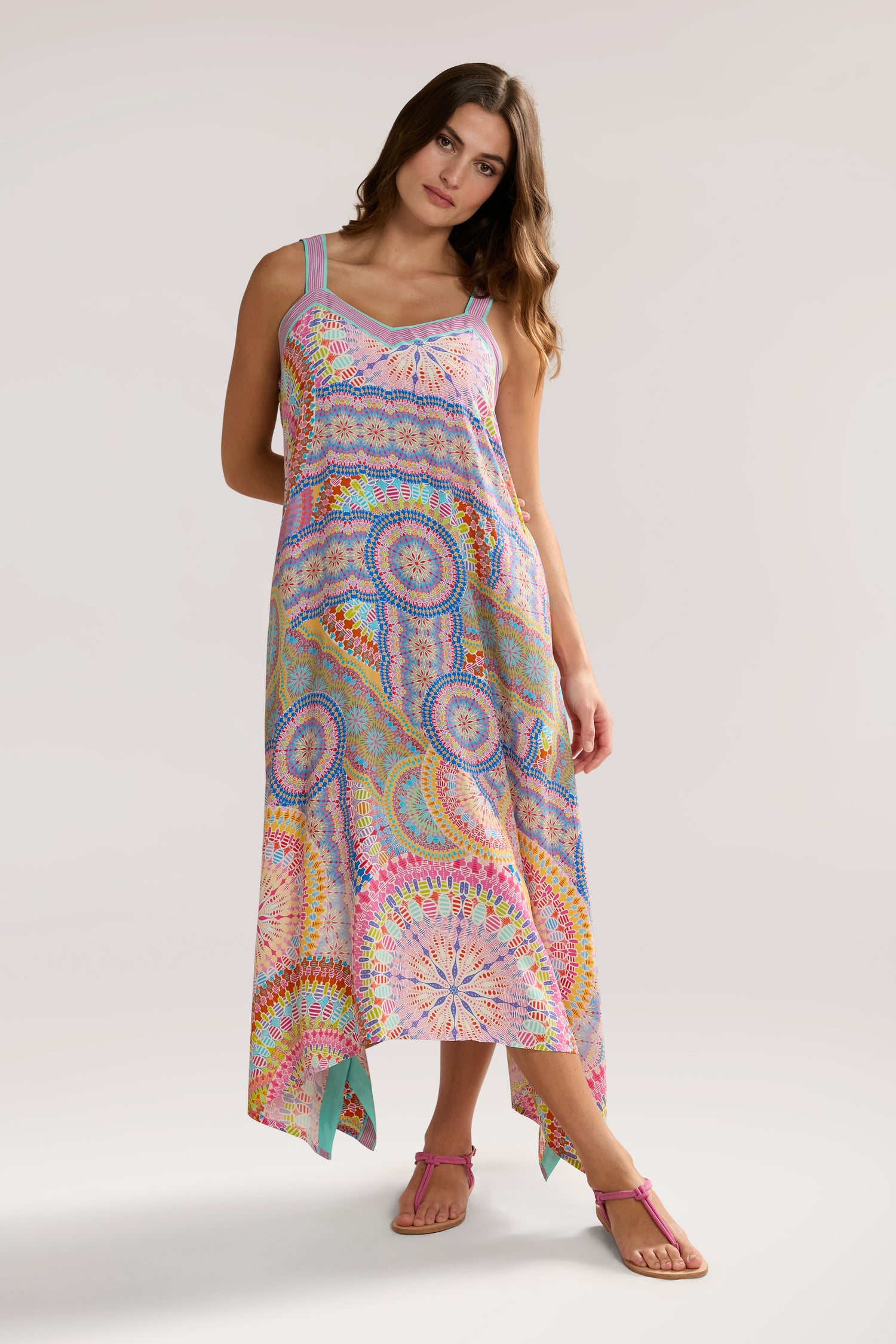 A woman in a Circle Mandala Sleeveless Dress and pink sandals stands against a neutral background.