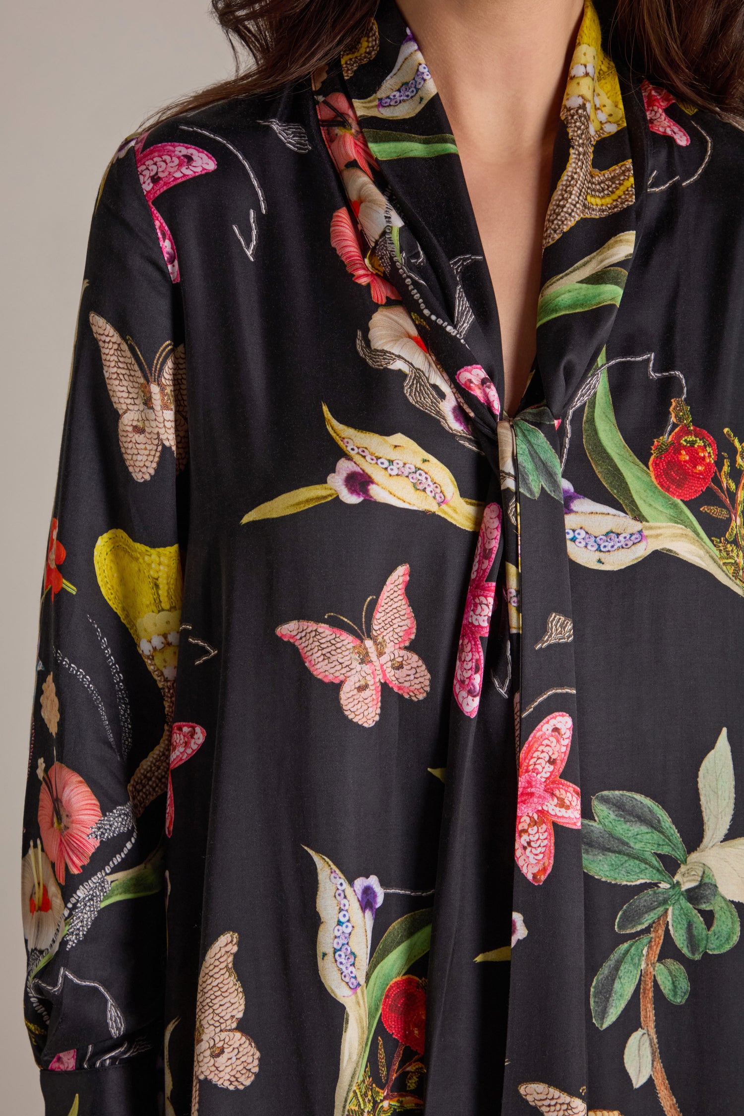 A person wearing the Vintage Floral Tie Front Dress, adorned with a colorful floral and butterfly print, adds a touch of elegance to the ensemble.