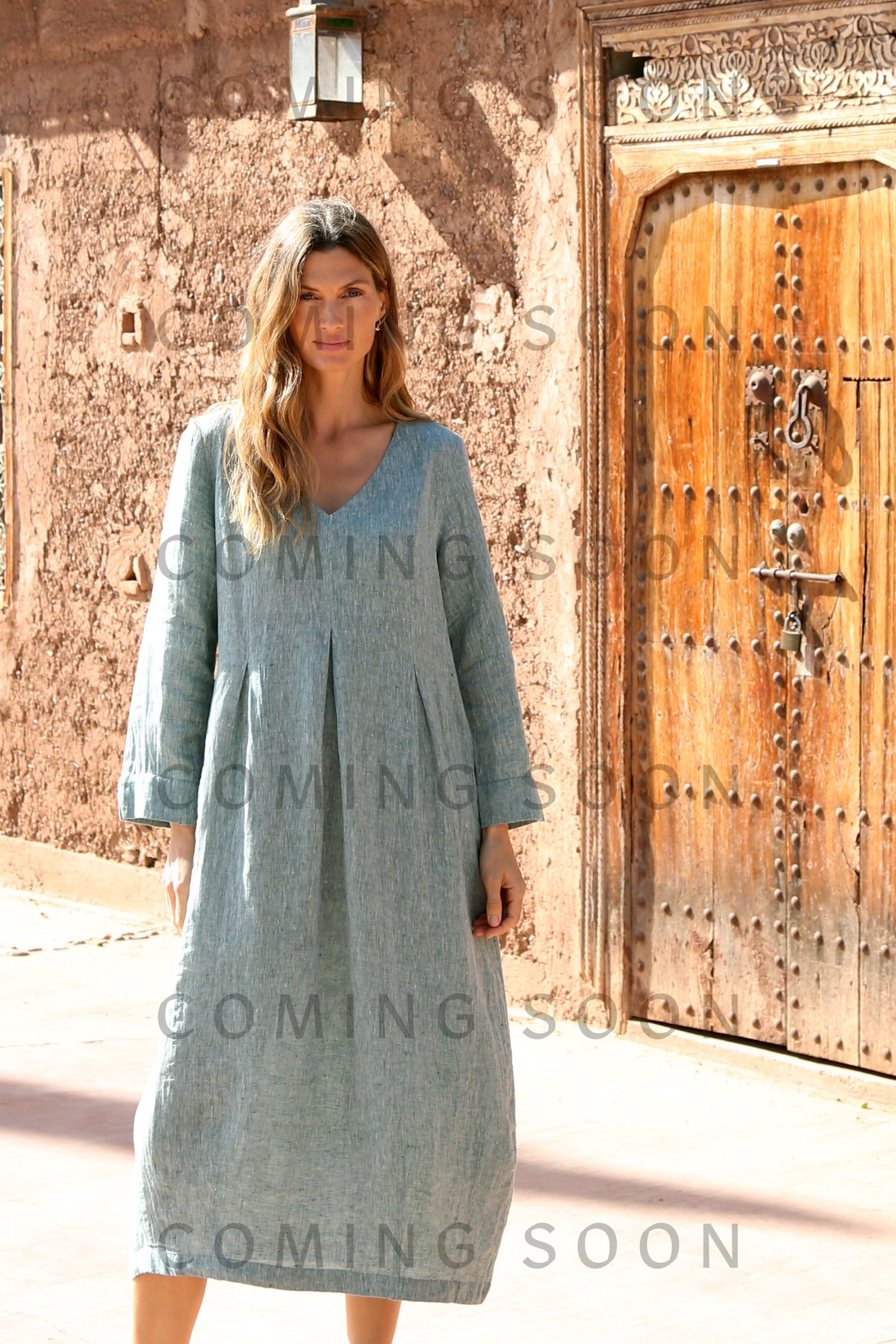 A woman in the Crinkle Linen Cross Dye Bubble Dress exudes effortless elegance, her style highlighted by the subtle charm of the GRD6859-TXCD accessory.