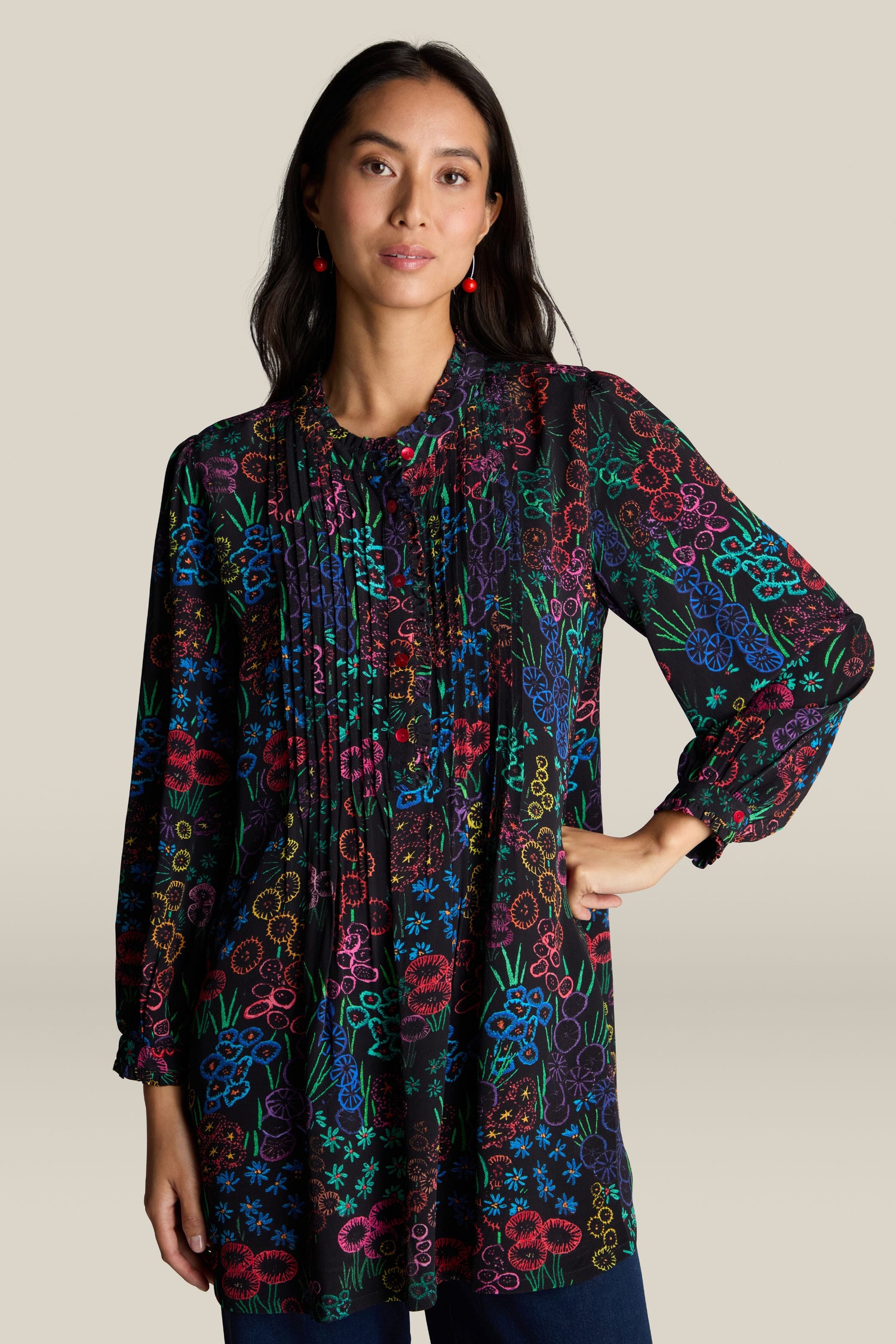 A woman stands with one hand on her hip, showcasing the Embroidered Floral Print Tunic with a grandad collar against a plain background.