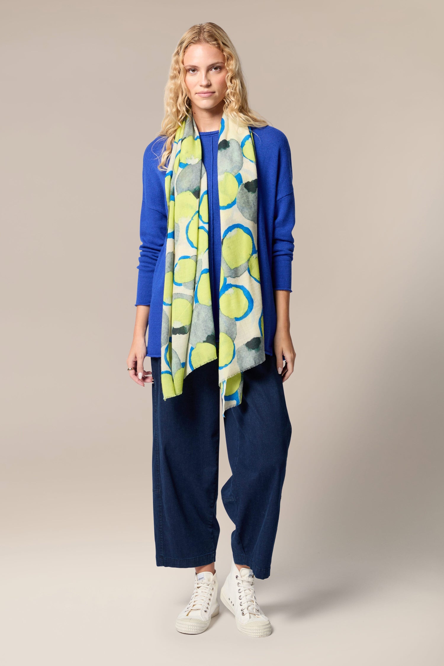 A woman wearing a luxurious Neon Spot Wool Scarf, perfect for all-occasion styling.