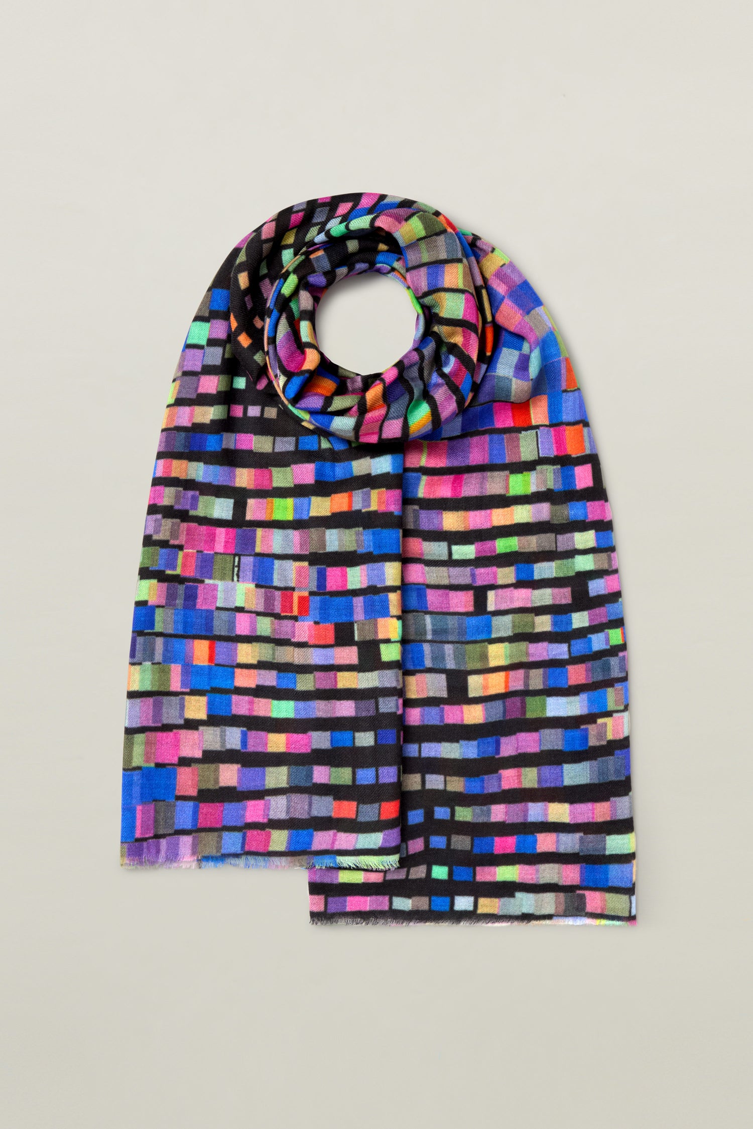 The Graduated Rainbow Squares Wool Scarf features a pattern of small, rectangular blocks arranged in horizontal rows, displayed on a plain gray background. This vibrant color scarf is crafted from premium wool for ultimate comfort and style.