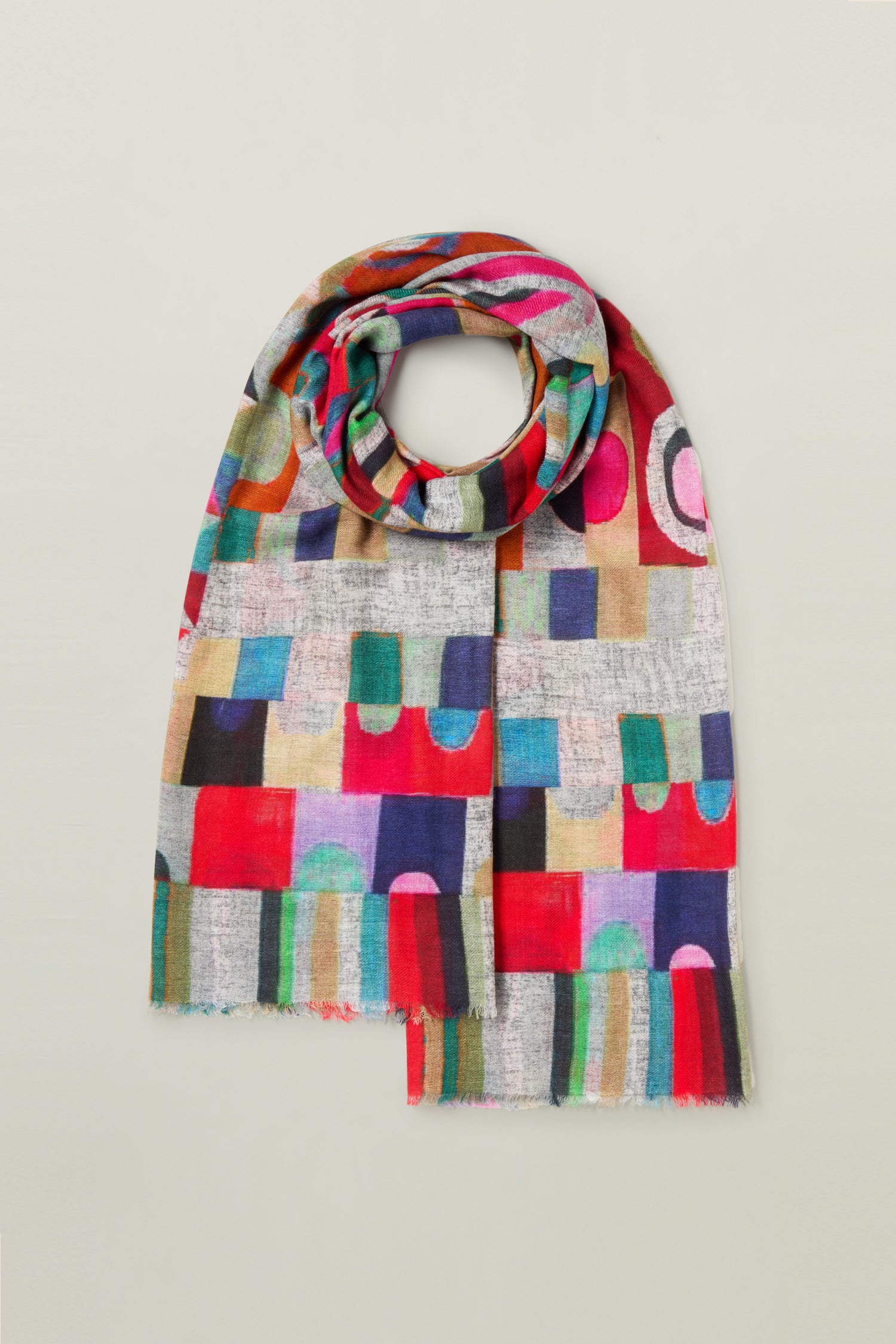 This Kandinsky Merino Wool Scarf showcases a vibrant geometric pattern with rectangles and circles in various shades of red, blue, green, and pink on a light background. Drawing inspiration from abstract expressionism, it makes for a striking accessory.