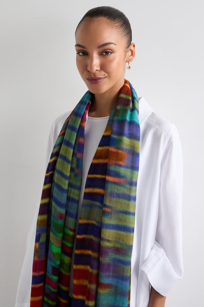 Against a plain white background, a person in a white shirt wears the Brushstroke Stripe Wool Blend Scarf, adding versatile styling to their simple look.