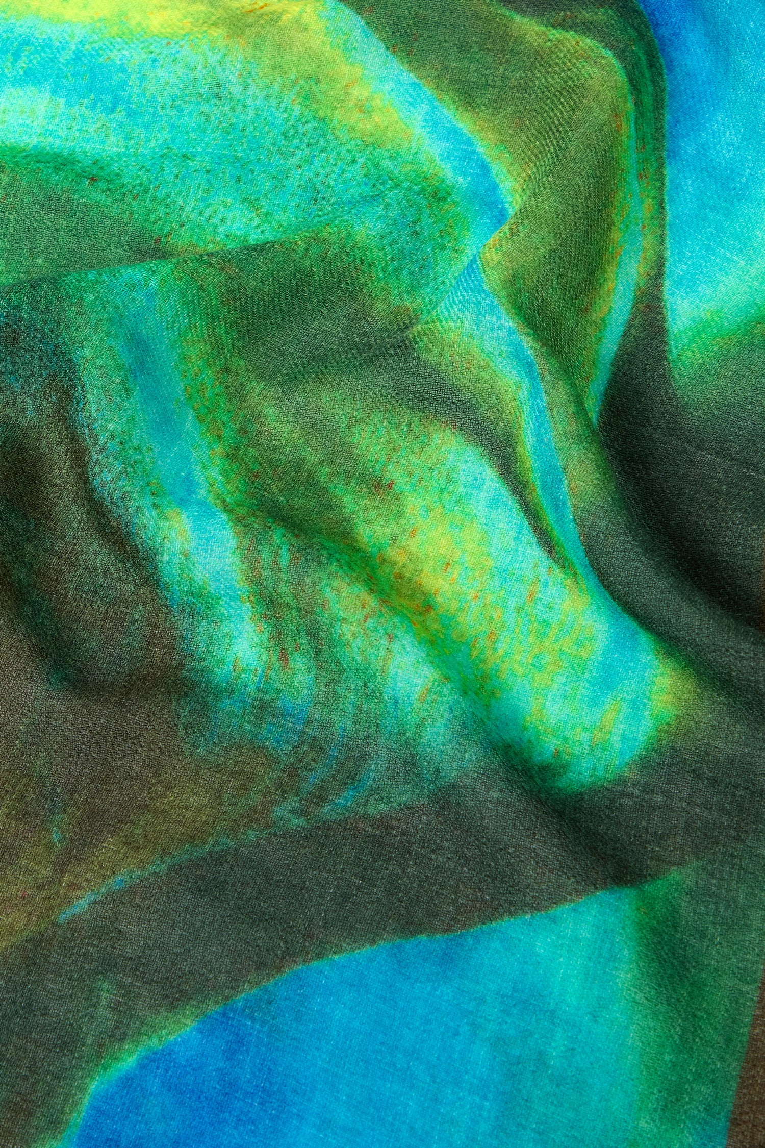 Close-up of the Ocean Deep Wool Scarf, highlighting its abstract patterns in sea-tone colors including green, blue, yellow, and hints of brown for a dynamic and flowing design.