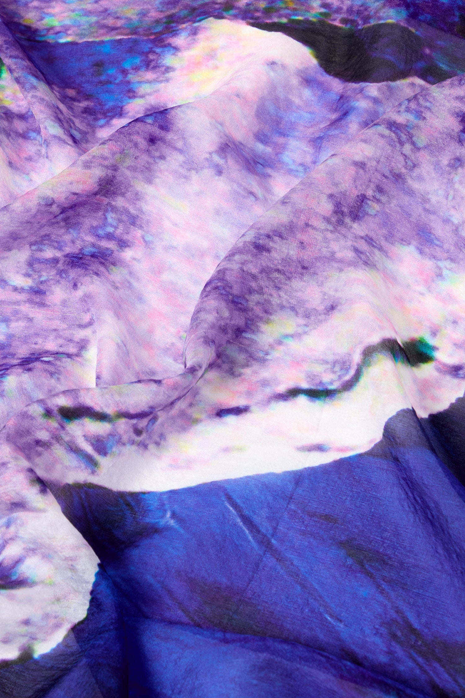 Close-up image of the Quartz Silk Scarf, showcasing a vibrant, abstract design with swirling patterns in shades of purple, blue, and white on a luxurious silk canvas.