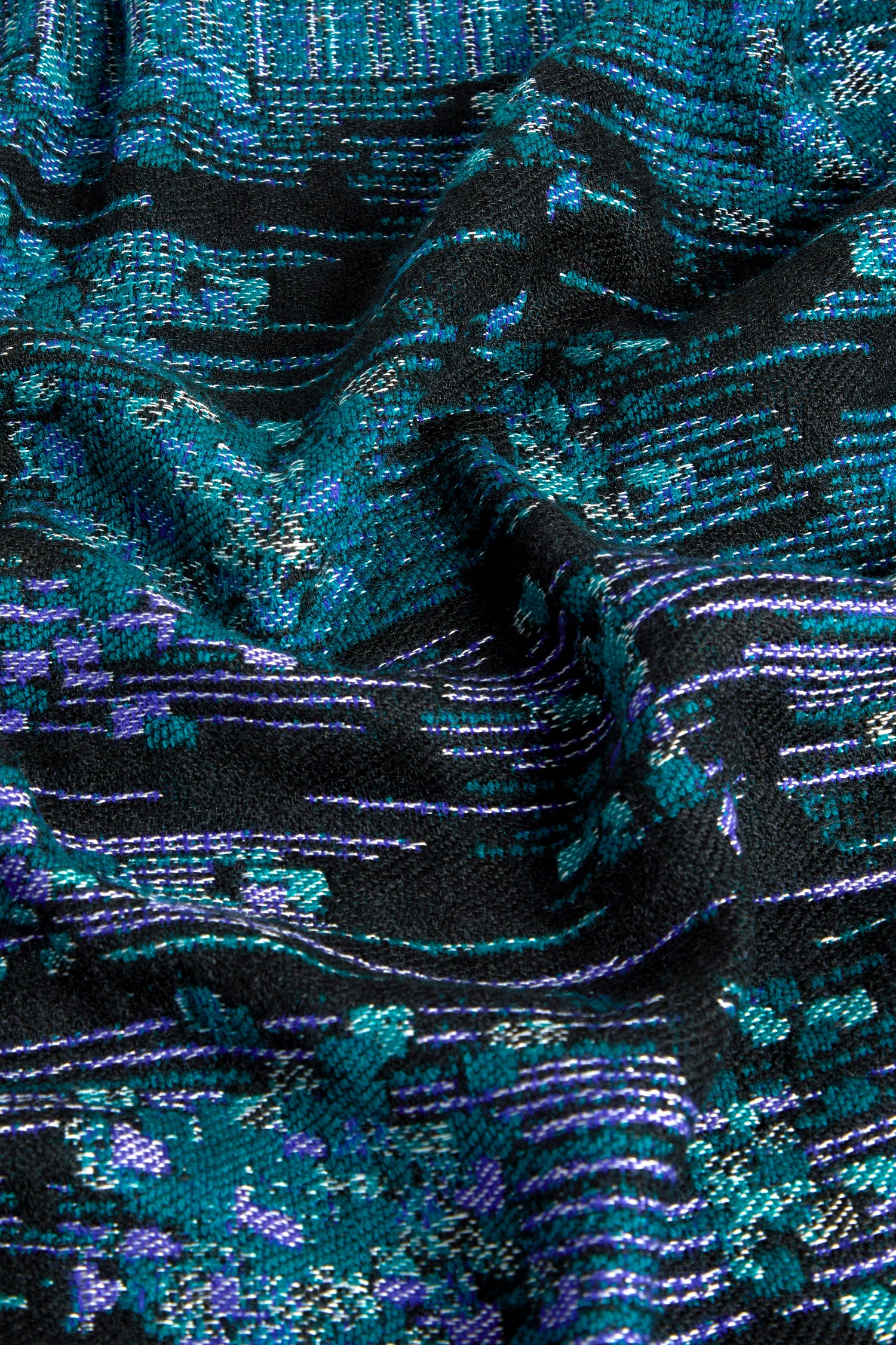 Close-up of the Midnight Stitch Scarf, showcasing its luxurious fabric adorned with intricate patterns of blue and green abstract shapes on a black background. Its slightly raised and uneven texture adds to the scarf's unique allure.