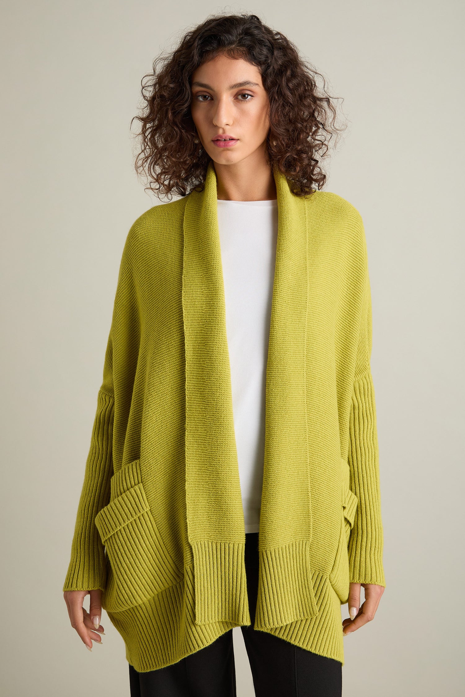 Person wearing the Pocket Detail Rib Cardi in lime green over a white shirt and black pants.