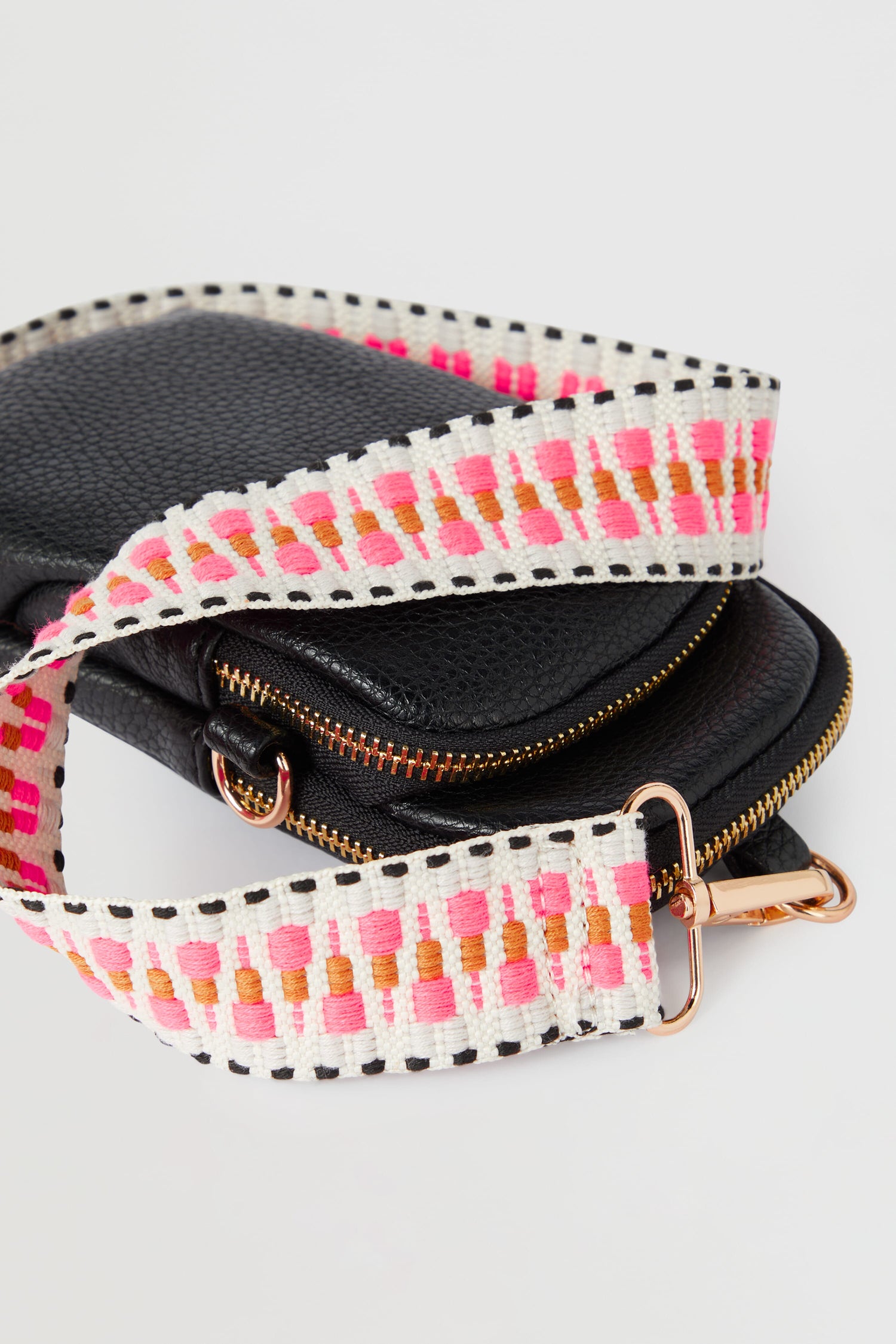 A stylish Mini Crossbody Bag in black and pink, featuring a trendy pink strap.