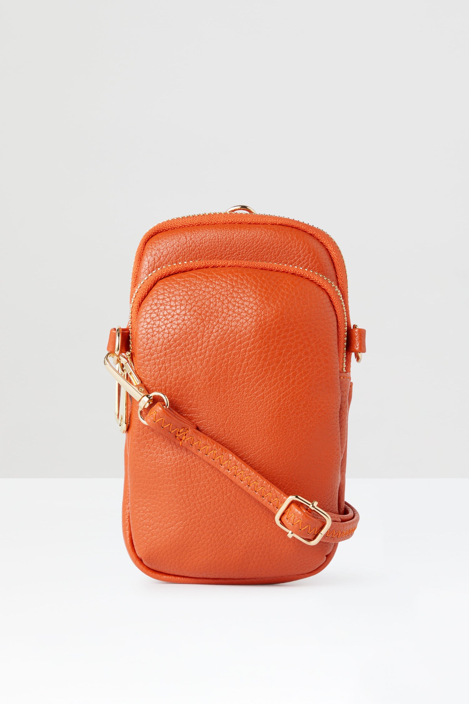 The Mini Crossbody Bag is on a white surface.