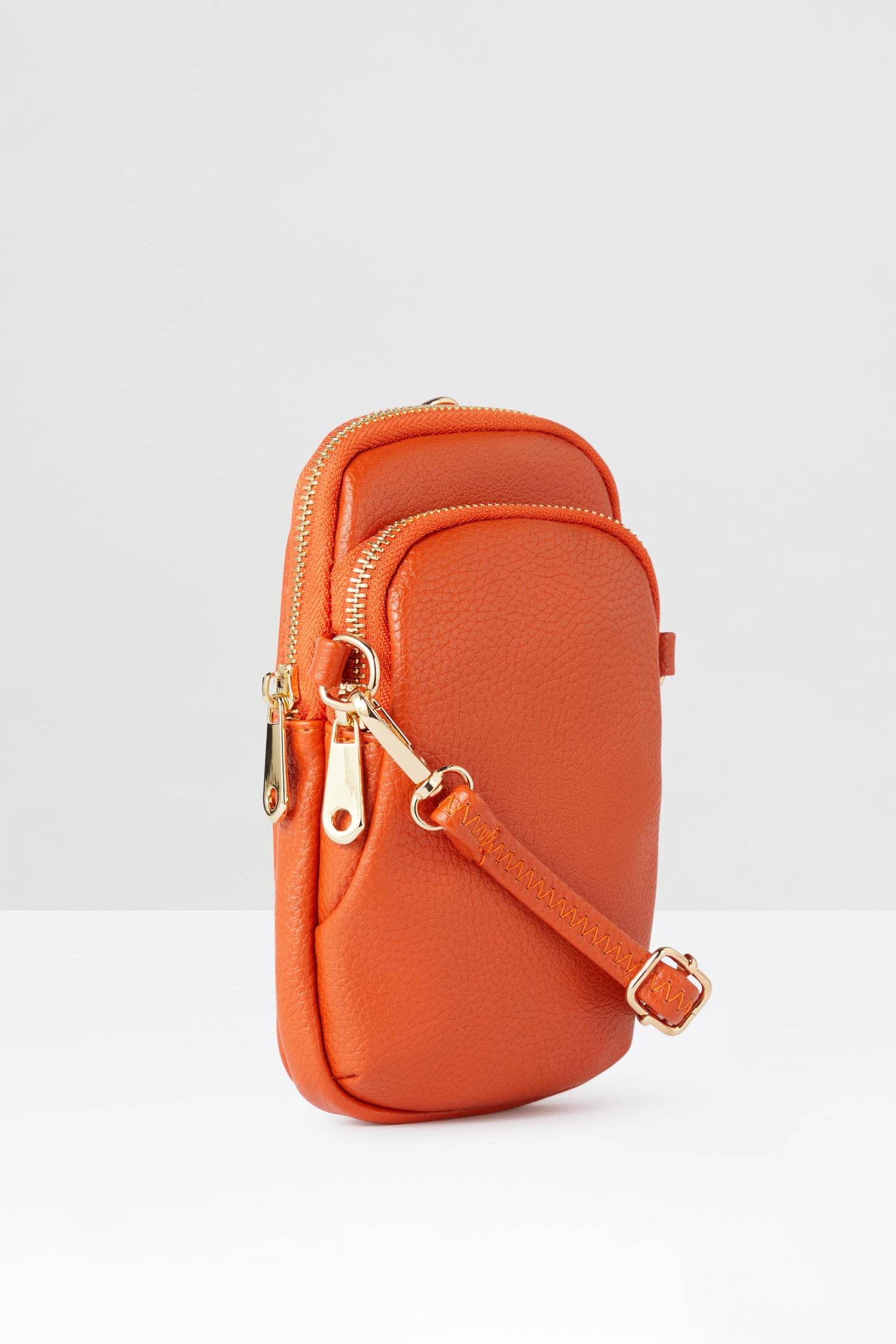 A stylish Mini Crossbody Bag orange crossbody bag with gold hardware.