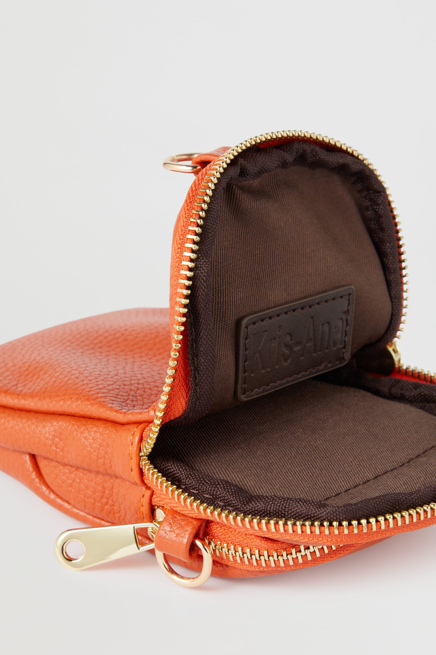 An orange Mini Crossbody Bag with a zipper, featuring style-led designs.